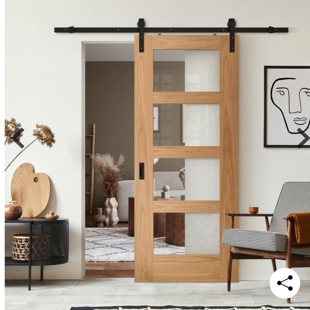 SLiding barn doors supplied & fitted Wooden sliding door with glass panels, set in a modern interior space.